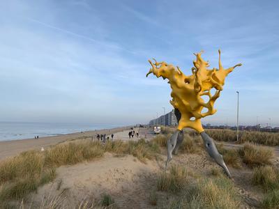 Beaufortkunstwerk Olnetop van Nick Ervinck: een gele splash die de golven voorstelt bovenop een duin die uitkijkt over de skyline van Middelkerke en de zee
