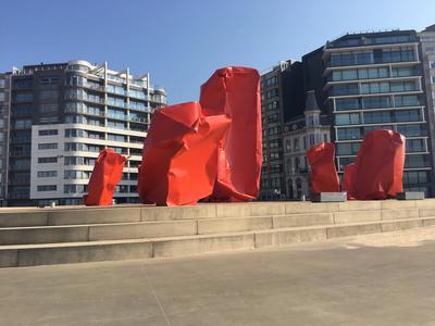 Beaufortkunstwerk Rock Strangers van Arne Quinze: grote rode gedeukte blokken op de zeedijk van Oostende