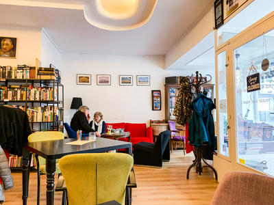Interieur 't Leeshuus VZW Oostende met rode en blauwe zetels en boekenkasen
