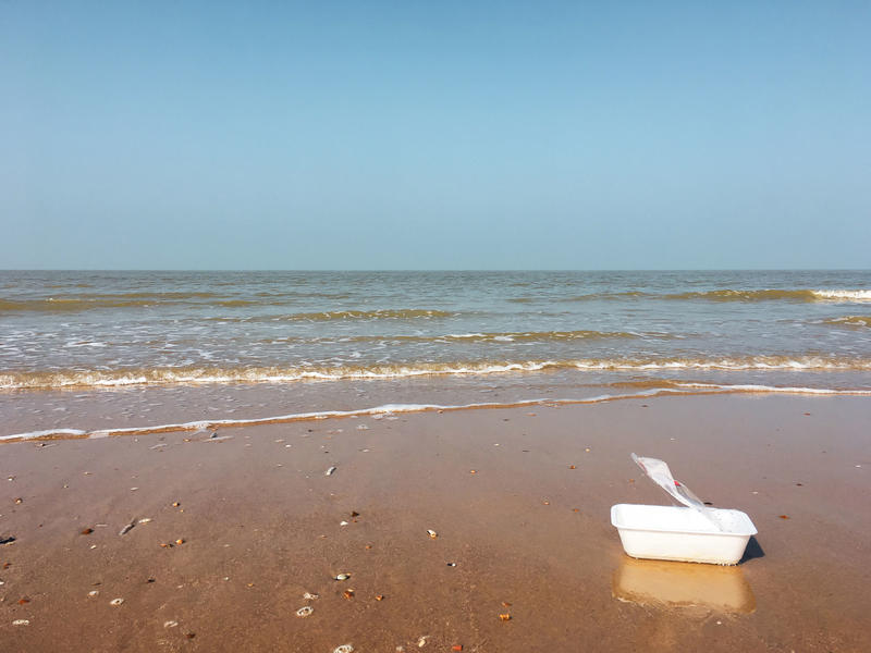Plastic bakje aan de zeelijn
