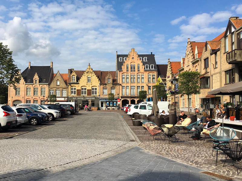 Markt van Nieuwpoort met terrasjes en geparkeerde auto's
