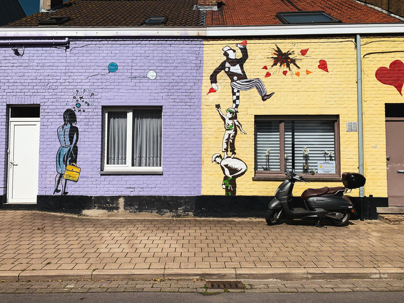 Kunstgevel van Annie Vanhee: paars en gele gevels met daarop Banksy-achtige figuren