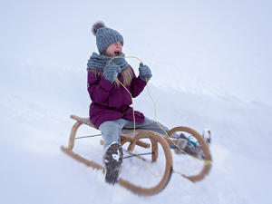 Kind op slee in de sneeuw